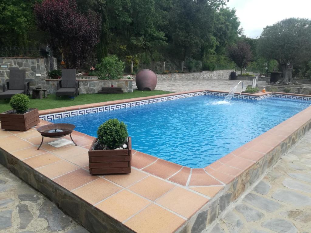 a swimming pool with a fountain in a yard at Cova Safaja in San Quírico Safaja