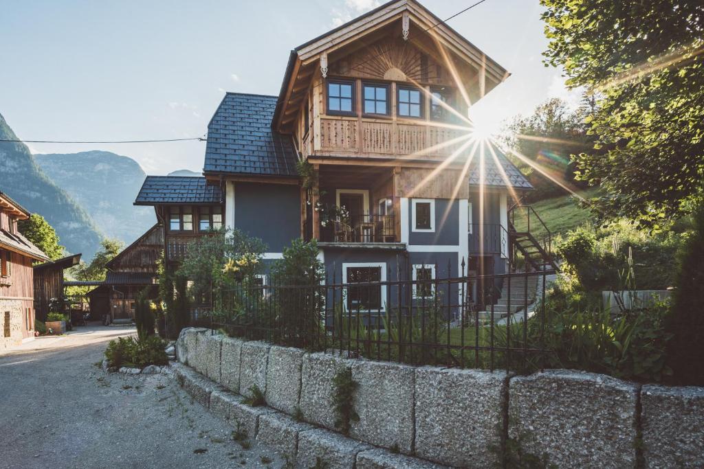 a house on a street with the sun behind it at Chalet am Sonnenhang in Obertraun