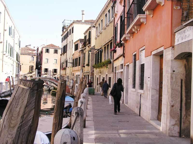 una mujer caminando por una calle al lado de los edificios en Ca' Turelli, en Venecia