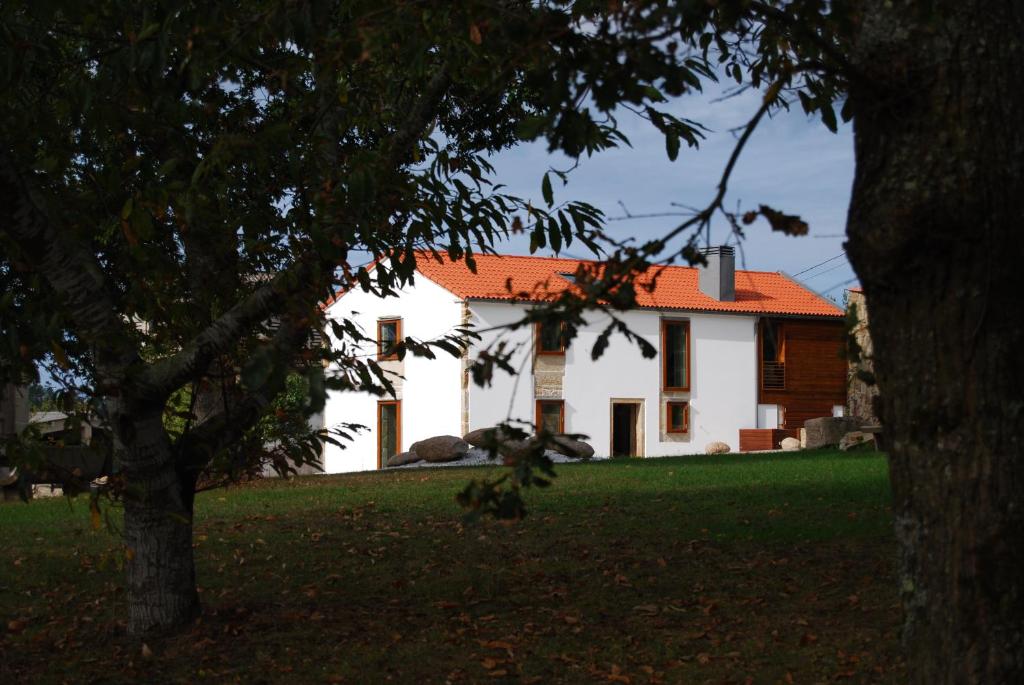 Biały dom z pomarańczowym dachem w obiekcie Casa do cruceiro na Costa da Morte w mieście Jornes