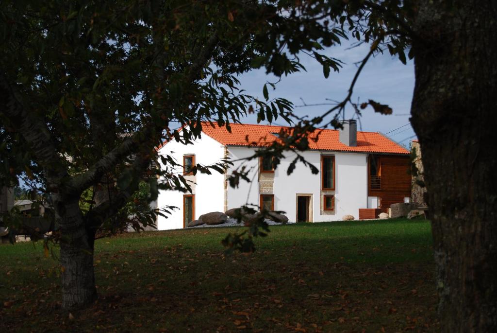 a white house with an orange roof at Casa do cruceiro na Costa da Morte in Jornes