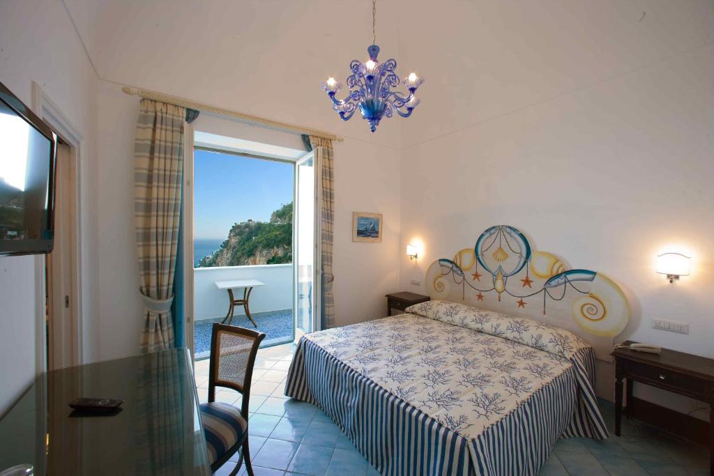 a bedroom with a bed and a large window at Palazzo Marzoli charme Resort - Small Luxury Hotel in Positano