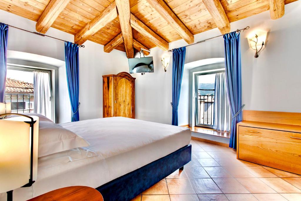ein Schlafzimmer mit einem großen Bett und blauen Vorhängen in der Unterkunft Residence San Giusto in Triest