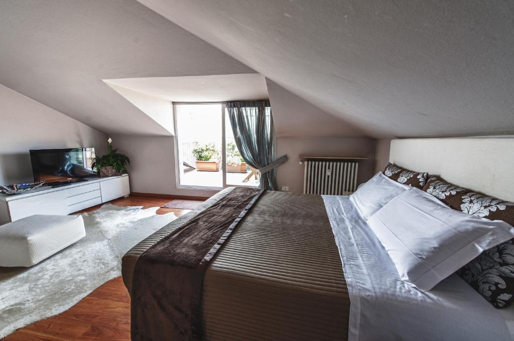 een slaapkamer met een groot bed en een raam bij Cute & Cozy Terrace in Bergamo