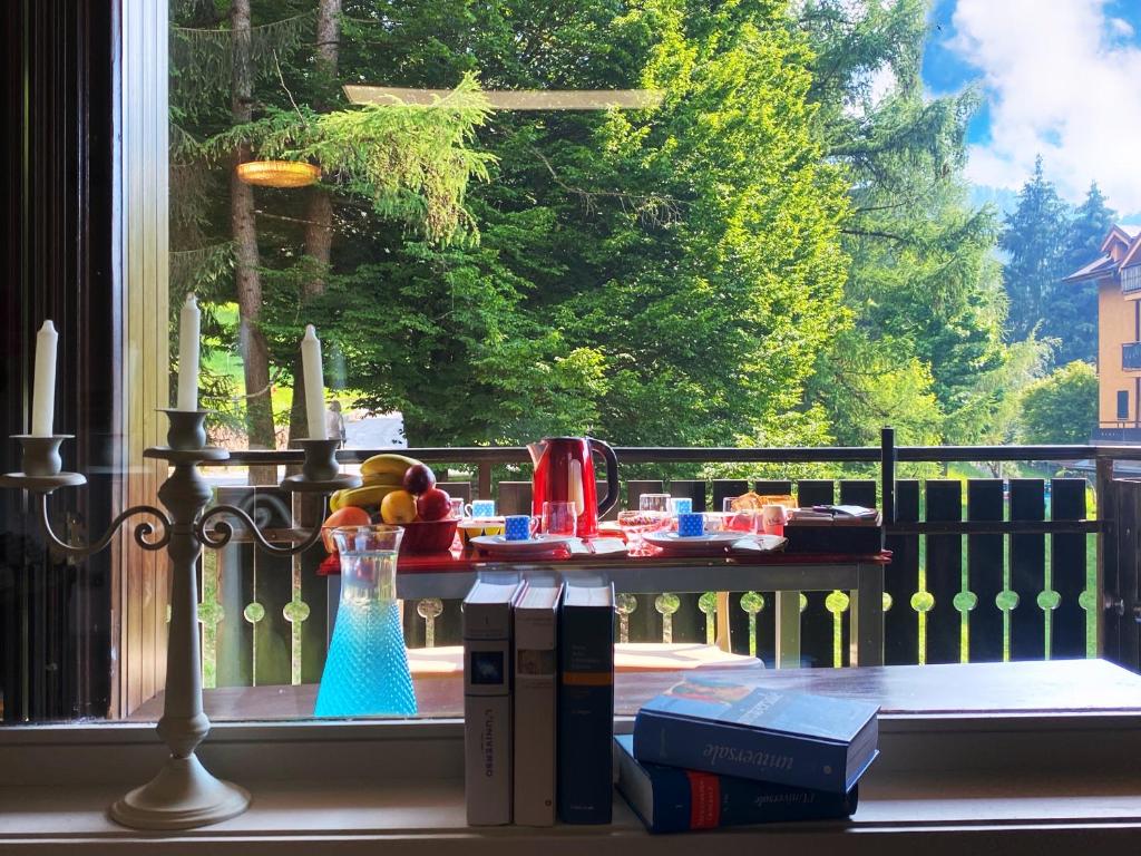 una finestra con tavolo e libri sul balcone di The little Nest ad Artogne