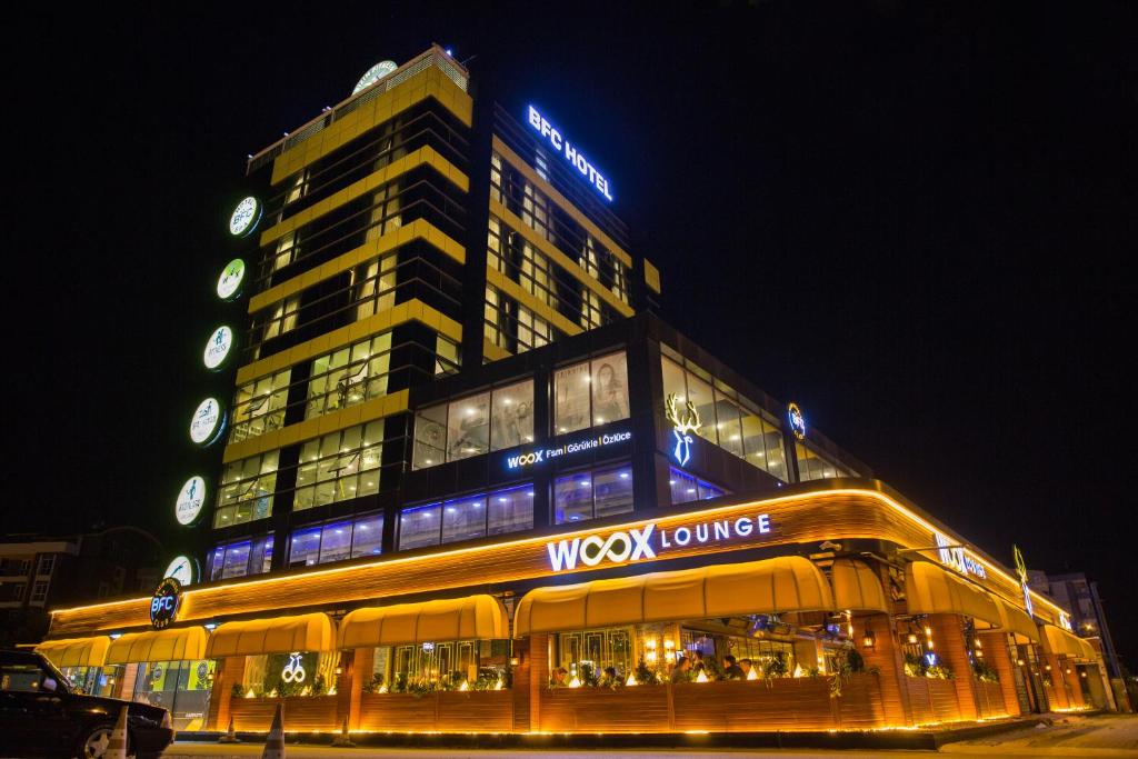 a large building with a wolfburning sign at night at Hotel BFC Spa & Sport in Bursa