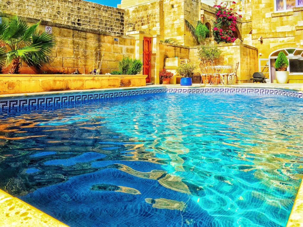 a swimming pool with blue water in a building at 21 A in Għarb