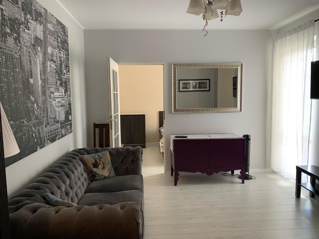 uma sala de estar com um sofá e um piano em Apartament Podróże Małe i Duże em Varósvia