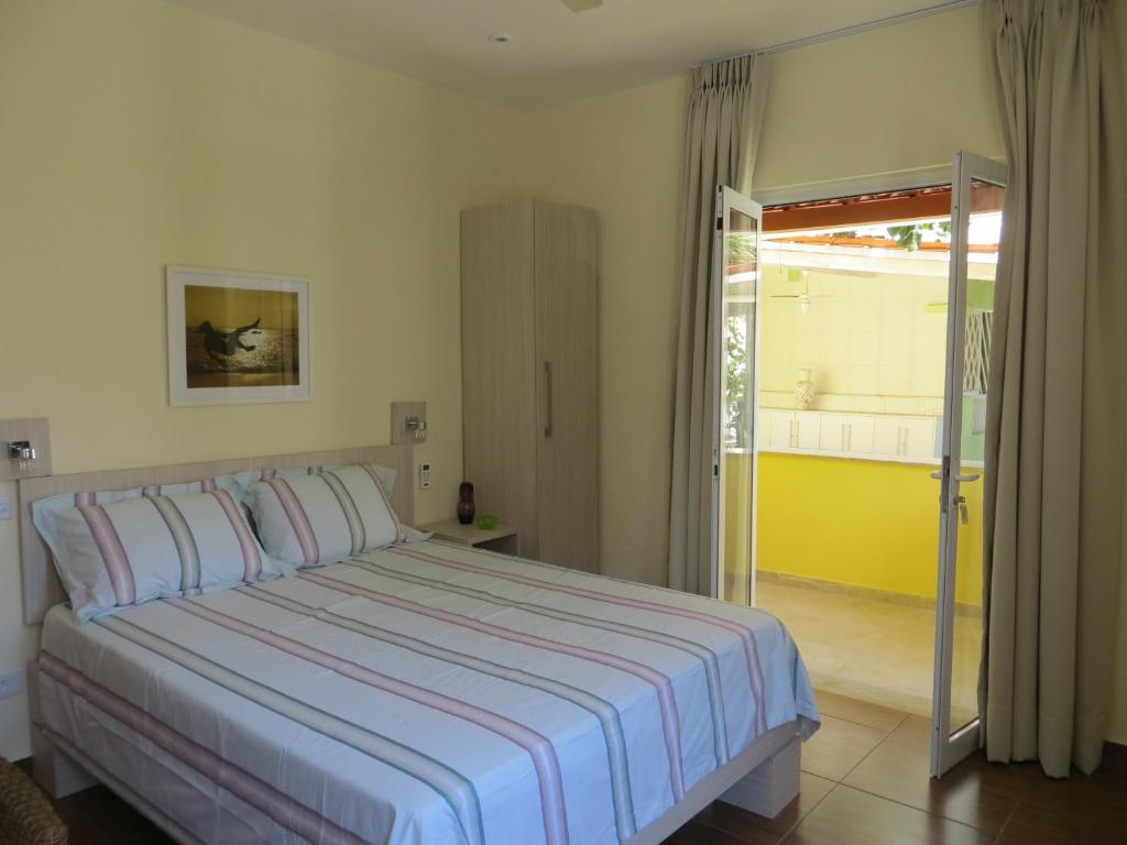1 dormitorio con 1 cama y puerta corredera de cristal en Casa Inglesa, en Salvador