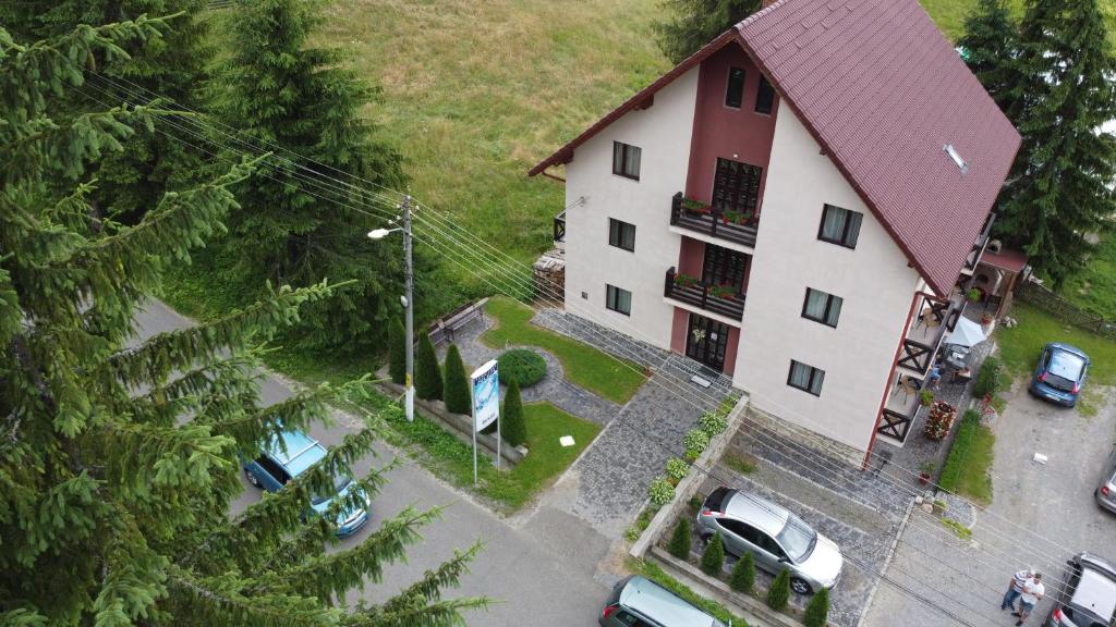 an overhead view of a building with cars parked in a parking lot at Pension Juliu's in Borsec