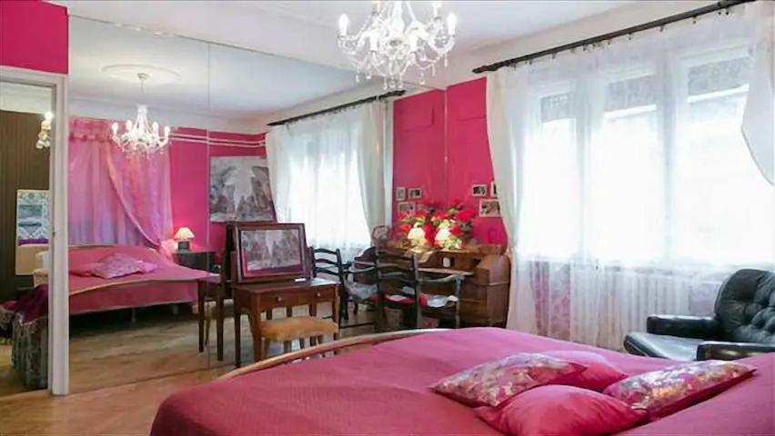 1 Schlafzimmer mit einem rosa Bett und einem Esszimmer in der Unterkunft FABOULOUS apartment in Belgrad