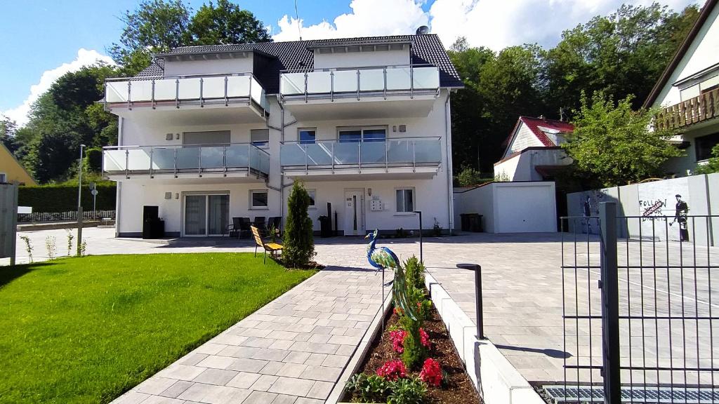 une maison blanche avec un jardin en face dans l'établissement Gästehaus Munk, à Guntzbourg