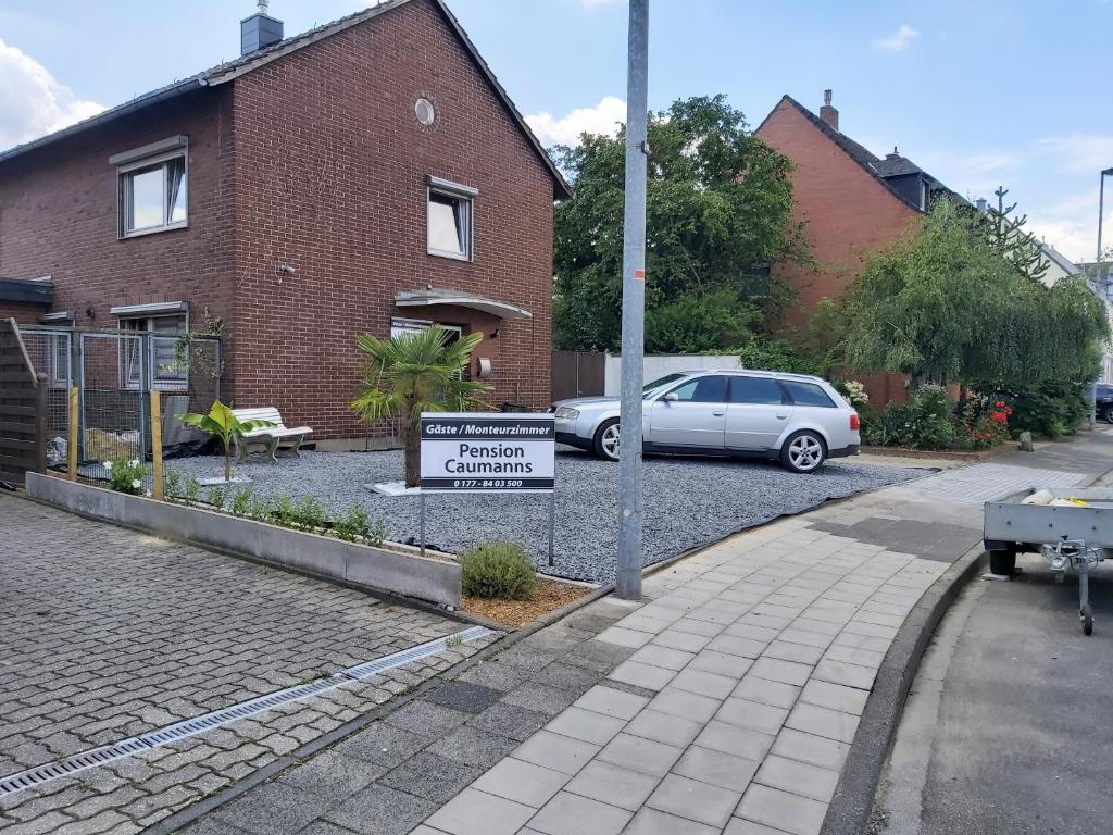 um sinal em frente a uma casa com um carro estacionado em Caumanns em Erkelenz