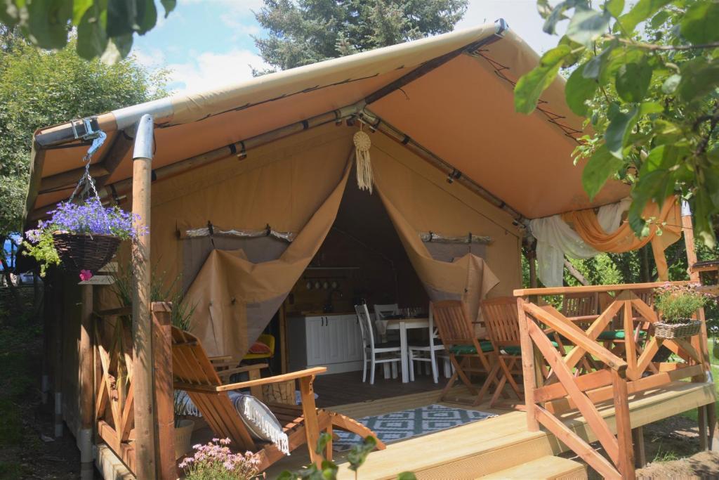 Beskidylla glamp في أوسترون: خيمة مع كراسي وطاولة في حديقة