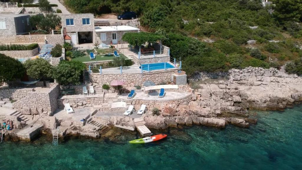 eine Luftansicht eines Hauses mit einem Boot im Wasser in der Unterkunft Villa sea oasis Ratac in Slano