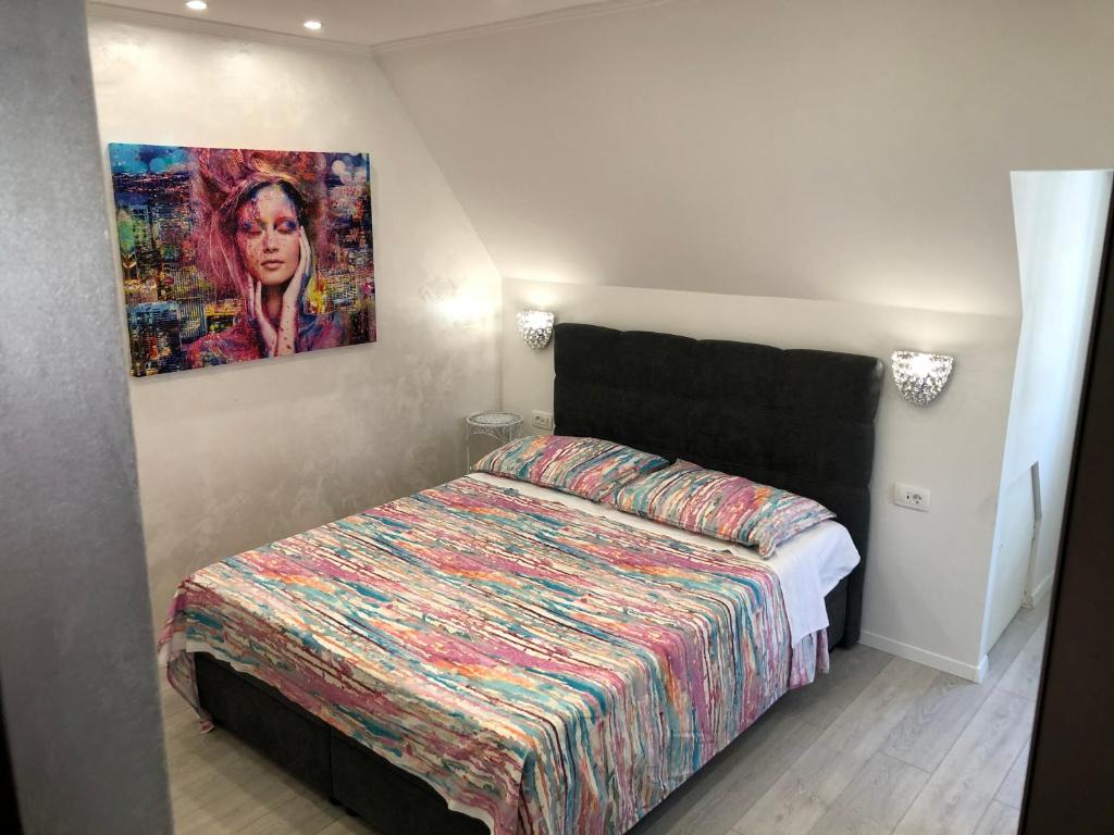 sypialnia z łóżkiem i obrazem na ścianie w obiekcie Apartment Vid w Splicie