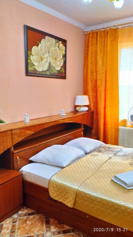 アドレルにあるApartments on Staronasypnayaのベッドルーム1室(ベッド1台付)が備わります。壁には花の絵画が飾られています。