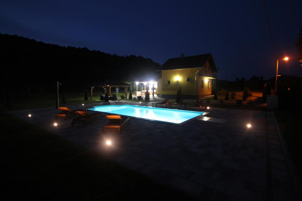 a swimming pool in a yard at night at Holiday Home Dalija in Otočac