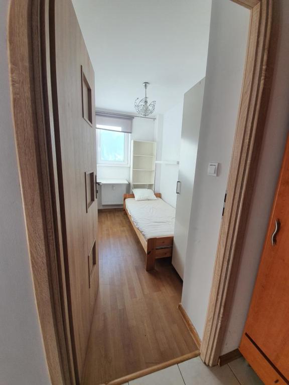 a small room with a bed and a hallway at Apartament Gdańsk Wszędzie blisko , wysoki parter in Gdańsk