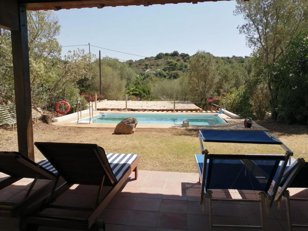 a patio with a table and chairs and a swimming pool at villa rubia in Villasimius