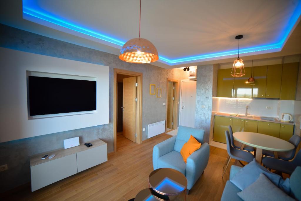 a living room with a couch and a tv and a table at Mount Inn Obradović in Zlatibor