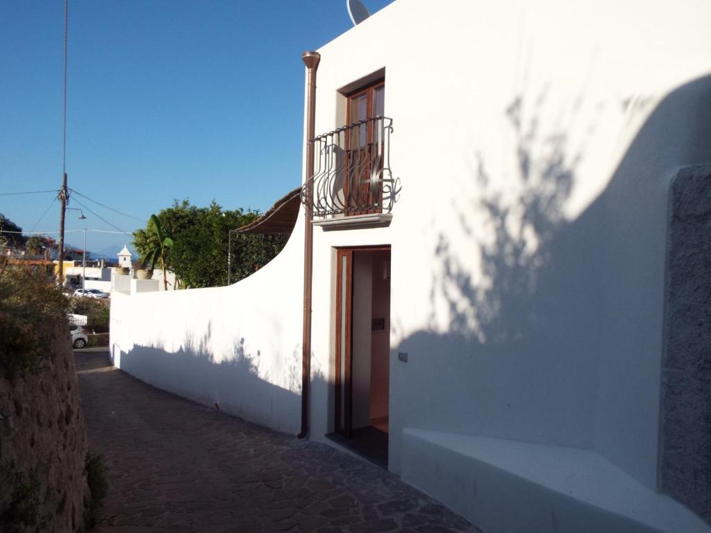 Edificio blanco con puerta y balcón en ANFORA Arancione, en Canneto