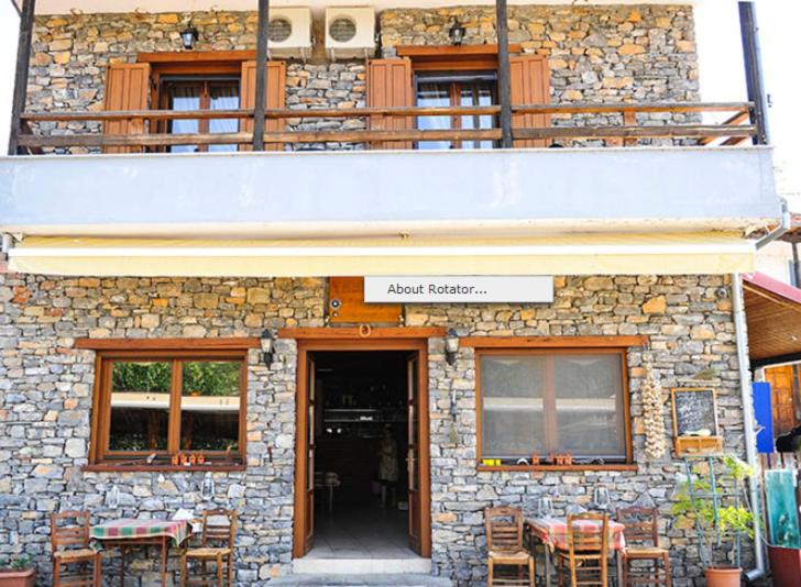 a stone building with a table and chairs in front of it at Guesthouse Syntrofia in Psarades