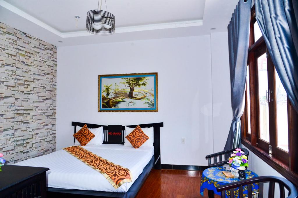 1 dormitorio con 2 camas y pared de ladrillo en Nohana Hotel, en Mui Ne