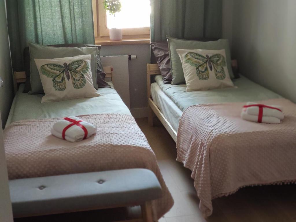 two beds in a small room with two bedsitures at Masuria Apartaments Ełk Nadjeziorna in Ełk