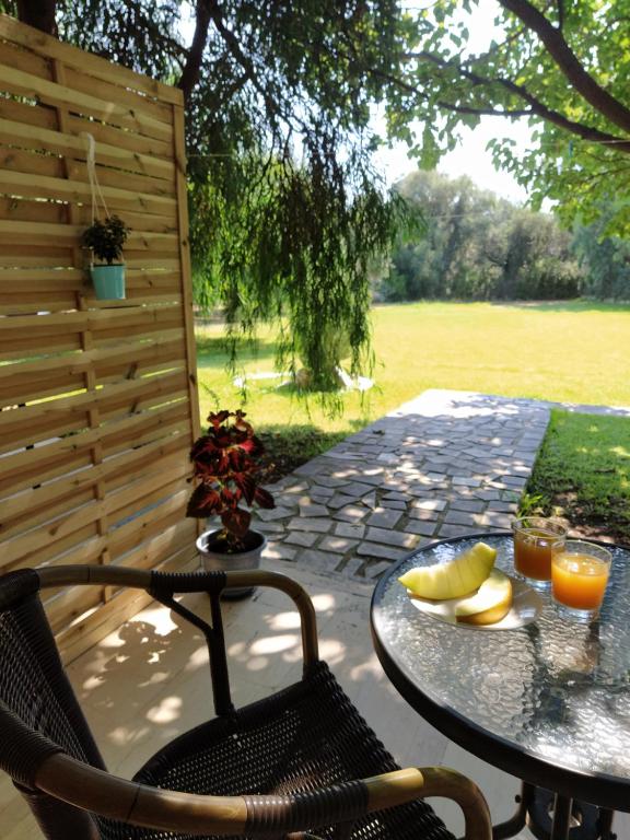 einen Tisch und Stühle auf einer Terrasse mit Obst darauf in der Unterkunft Filoxenia Apartments in Rizá