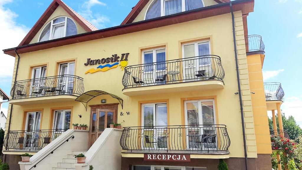 a yellow building with balconies on it at Janosik II in Ustronie Morskie