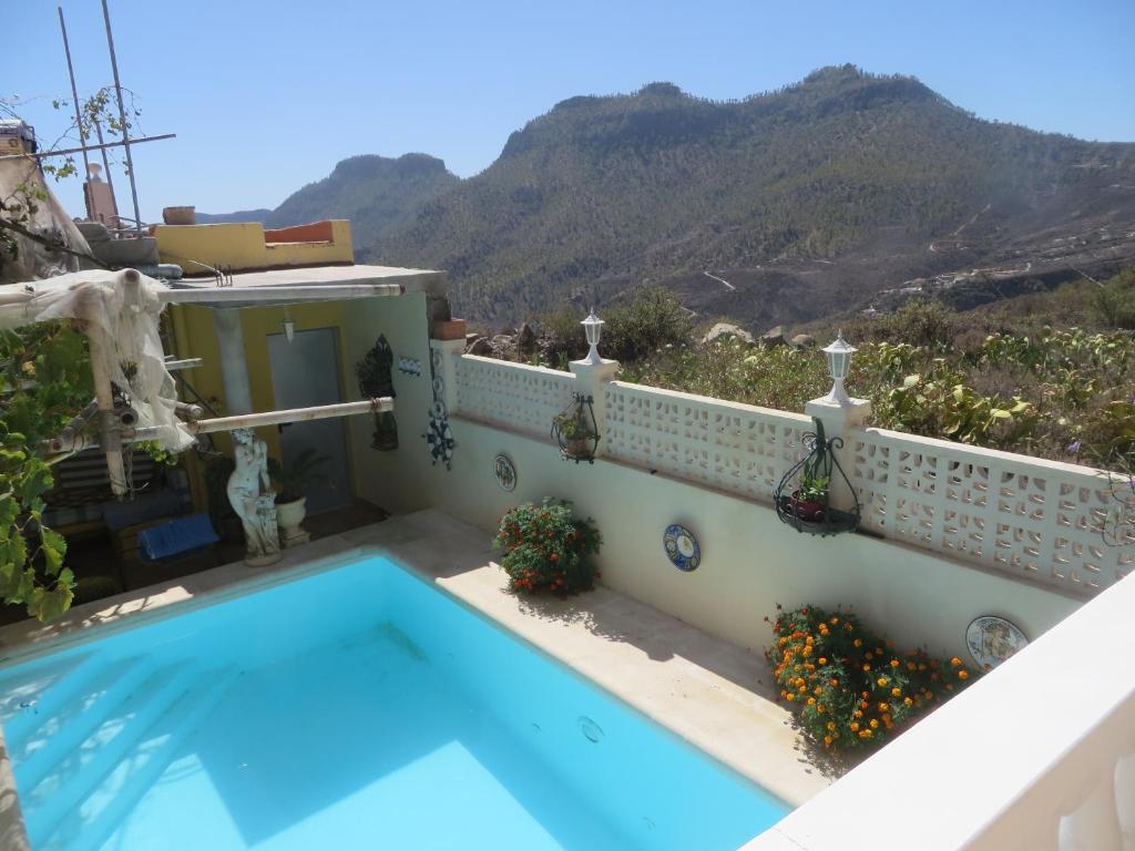 uma casa com piscina e montanhas ao fundo em Finca Cortez em San Bartolomé