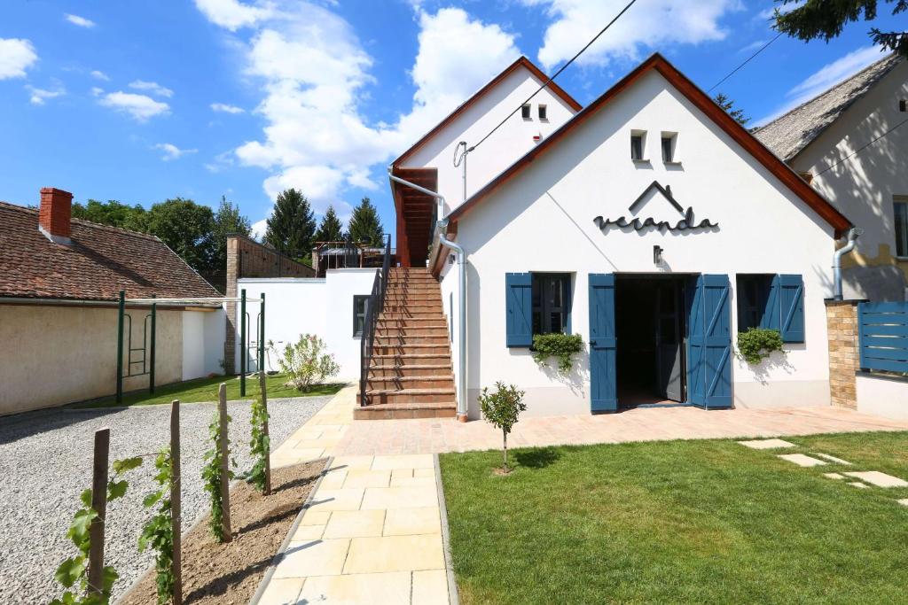 una casa blanca con una escalera que conduce a ella en Veranda, en Villány