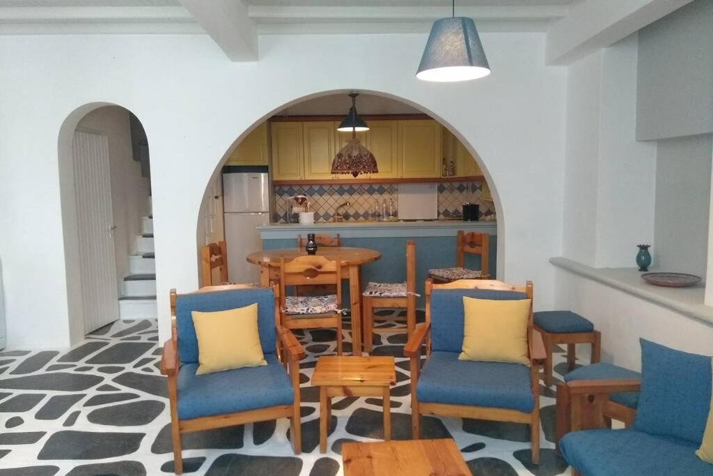 a room with a table and chairs and a kitchen at Nikos & Efi Fabrica Residence in Megali Ammos