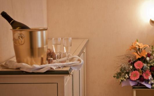 a table with wine glasses and a bottle of champagne at Hotel Florida in Venice