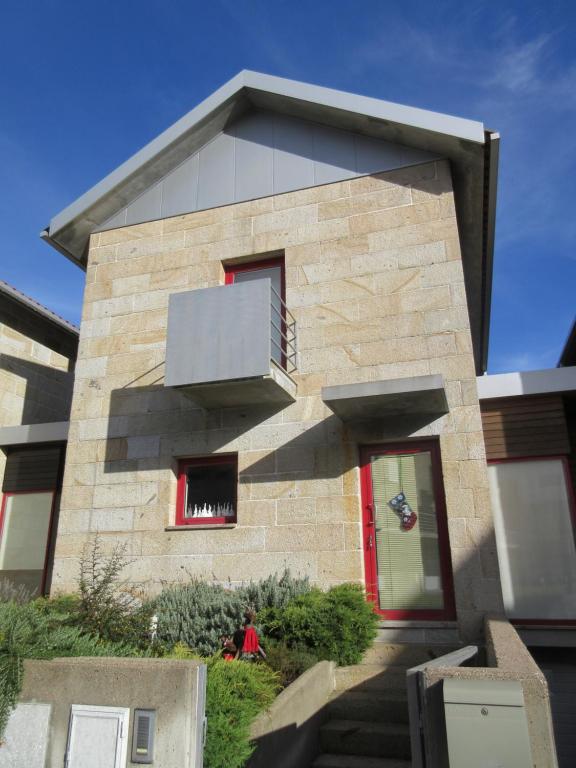 カストロ・ラボレイロにあるVillas do Laboreiro-Casa 6の赤いドアと階段のあるレンガ造りの家