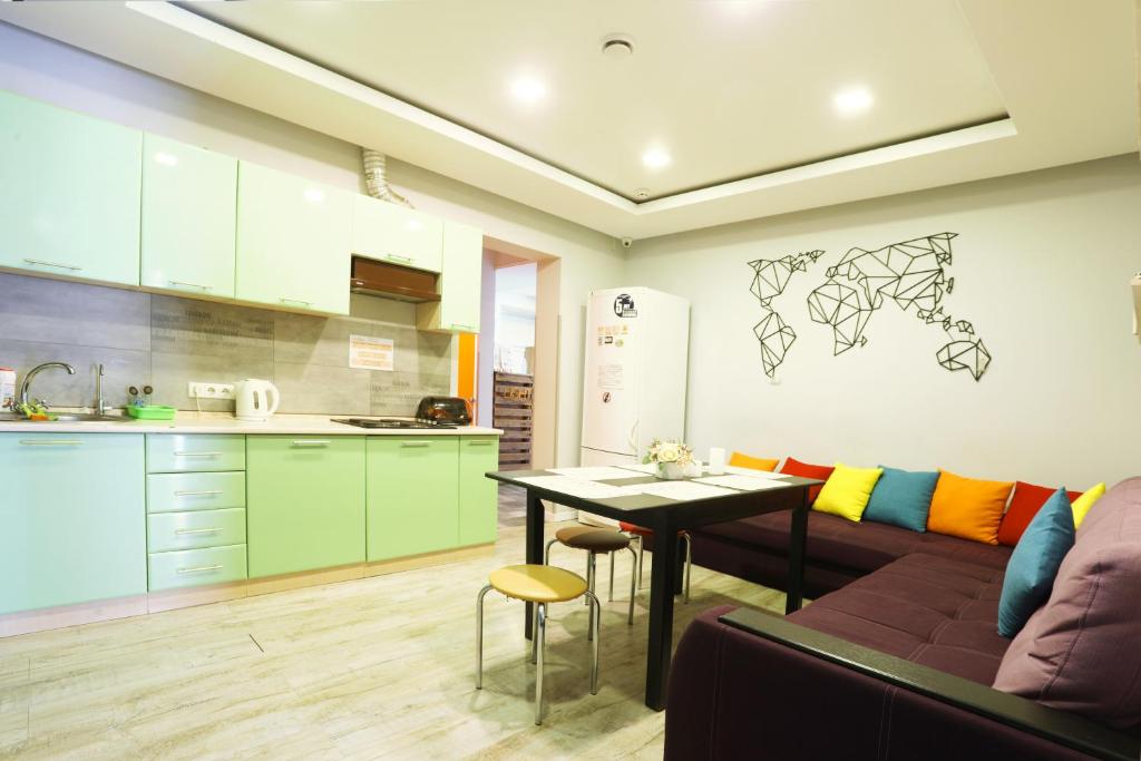 una cucina e un soggiorno con divano e tavolo di Light Life Hostel a Kiev