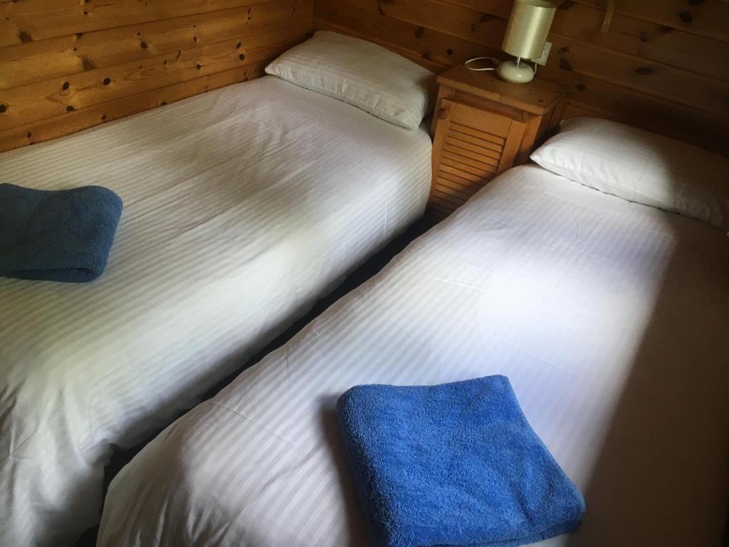 2 letti posti uno accanto all'altro in una stanza di Chalet 2 a Tyndrum