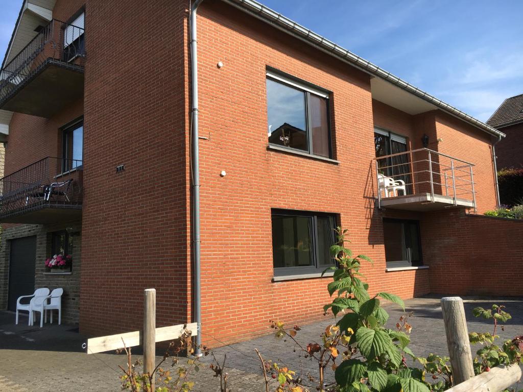 ein Backsteingebäude mit einem Hund auf dem Balkon in der Unterkunft Chalet M in Eupen