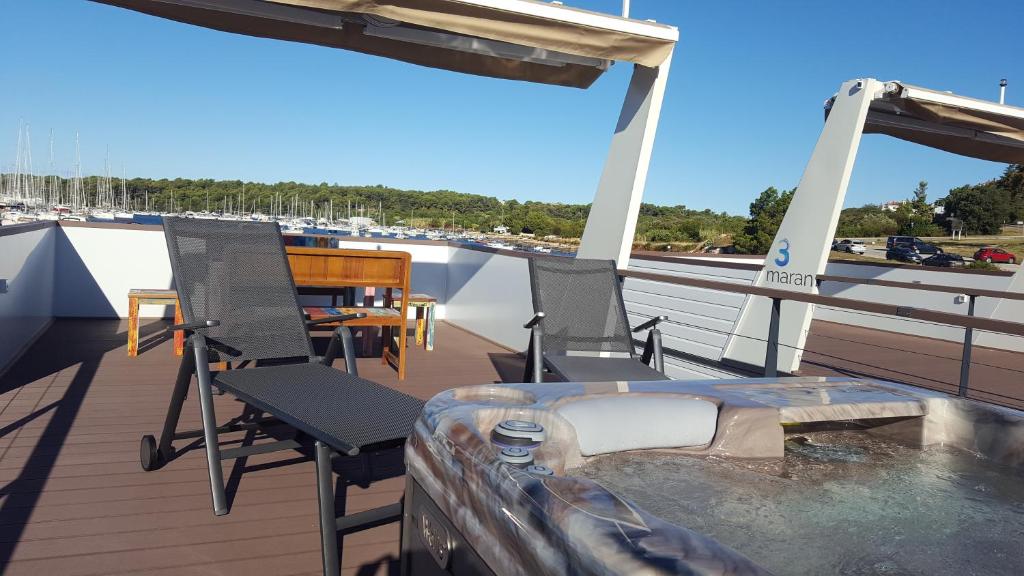 a deck with chairs and a table on a boat at House Boat - Floating House Sofia in Pula