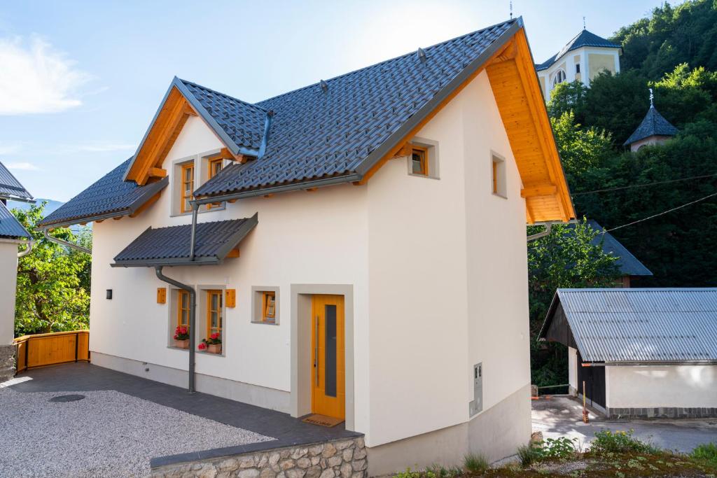 a white house with a blue roof at Holiday house Zupanc in Bohinj