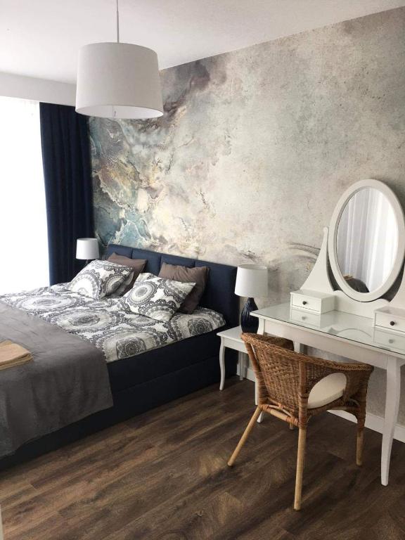 sypialnia z łóżkiem, toaletką i lustrem w obiekcie Apartament Amalia z tarasem widokowym i bocznym balkonem w Rewalu