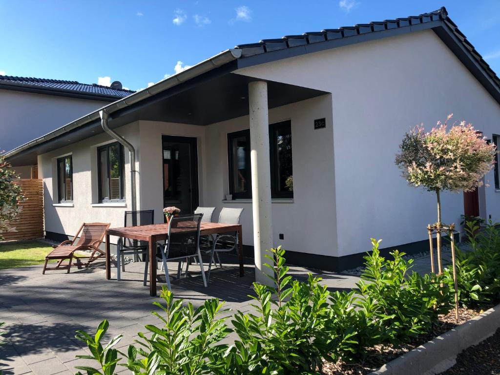 un patio con tavolo e sedie di fronte a una casa di Ferienhaus Malte Büsch a Barlt