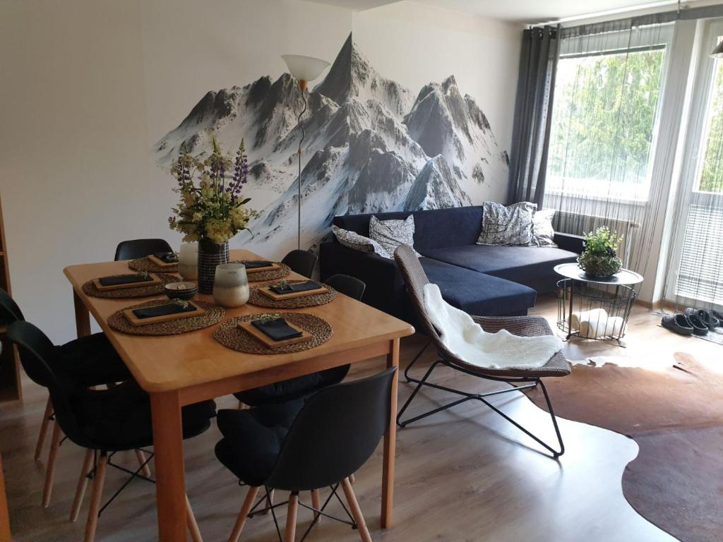 塔昌什卡什特爾巴的住宿－3 IZBOVÝ krásny Apartmán DAVID A7 v Tatranskej Štrbe，客厅配有桌子和蓝色沙发