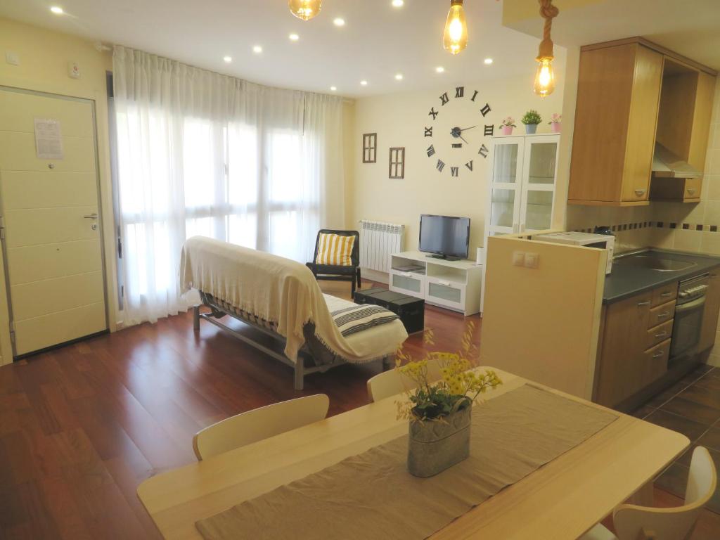 cocina y sala de estar con mesa y sofá. en Coqueto apartamento Las Margas Golf, en Sabiñánigo