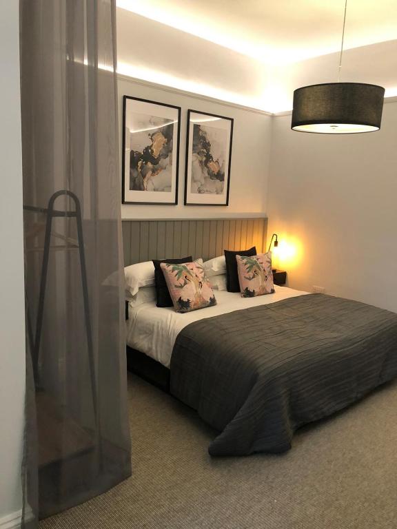 a bedroom with a large bed with two pictures on the wall at Blakeney House in Blakeney