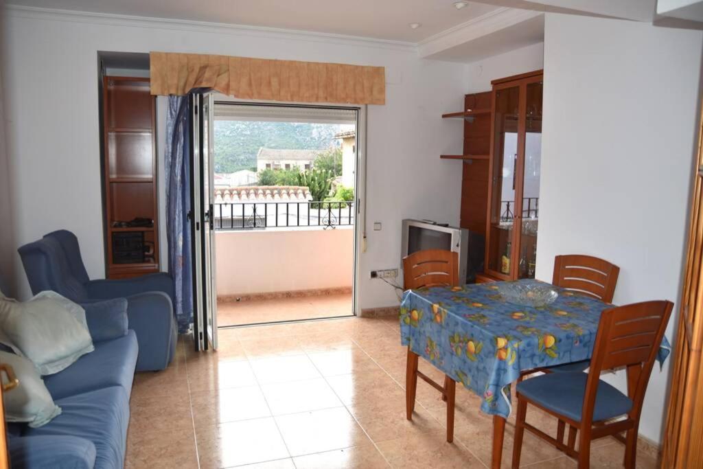ein Wohnzimmer mit einem blauen Sofa und einem Tisch in der Unterkunft APARTAMENTOS GALLACH (LA ERMITA) in Chulilla