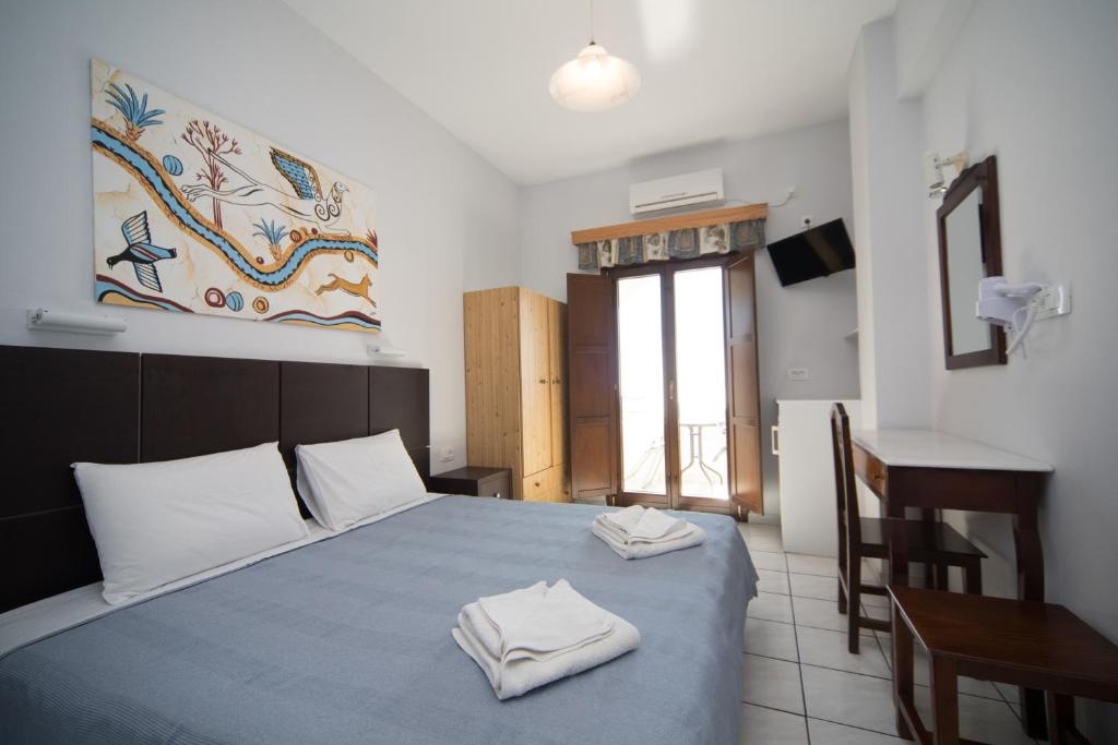 een slaapkamer met een bed met twee handdoeken erop bij Villa Stella in Fira