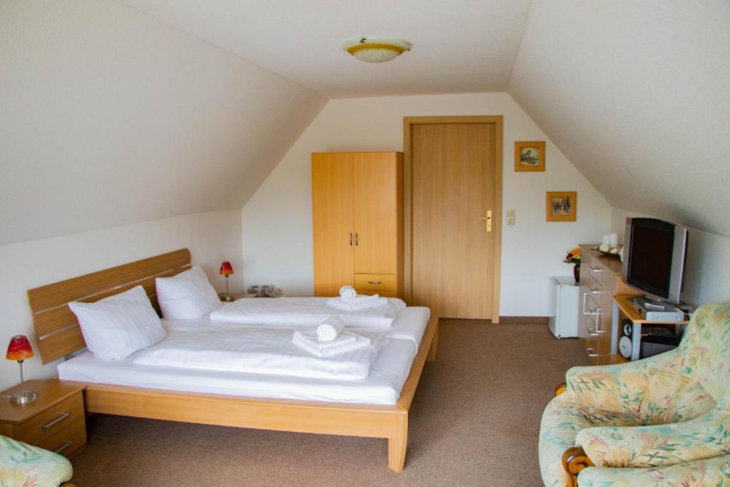 1 dormitorio con 1 cama, TV y sofá en Ausflugsrestaurant & Pension Aalbude & Hausfloßvermietung am Kummerower See, en Dargun