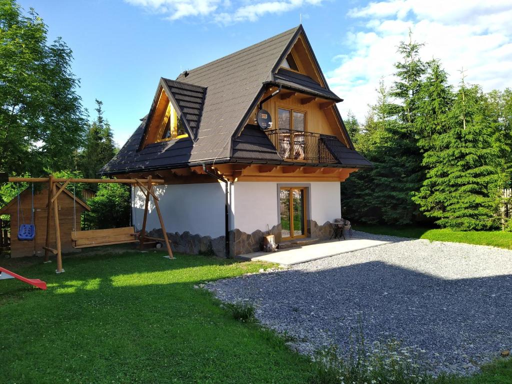 uma pequena casa com um telhado de gambrel em Kirowy Domek em Kościelisko